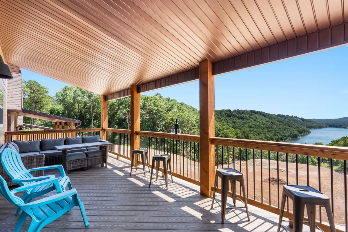 An outdoor seating area on an elevated deck, featuring comfortable chairs and a wide, unobstructed view of the lake. The setting is ideal for socializing or enjoying peaceful moments alone, with wooden railings and natural surroundings.